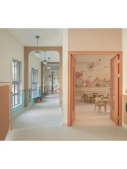 A view from the corridor into one of the desert-themed classrooms, showing the seamless transition between spaces. The warm color palette and playful details create a welcoming atmosphere from the moment you approach the room.