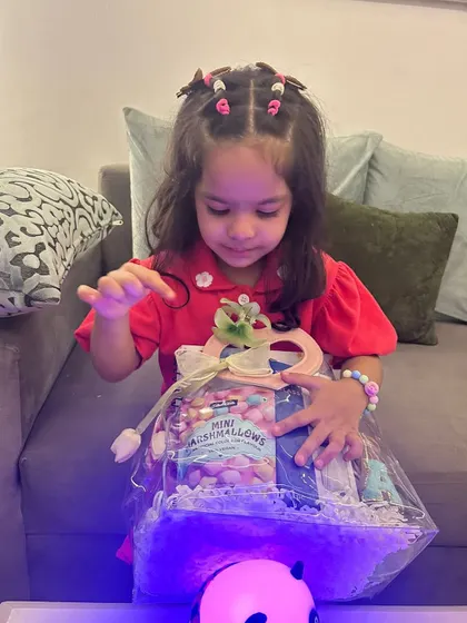 A young girl unboxing her Rakhi hamper. I love seeing the excitement and curiosity as they discover each item inside.