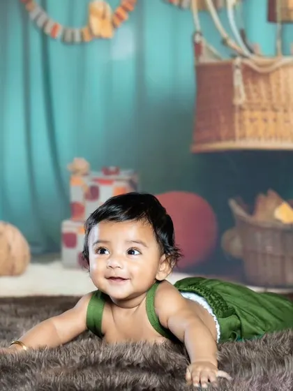 A sweet smile from a baby lying on a furry rug during our travel-themed shoot.