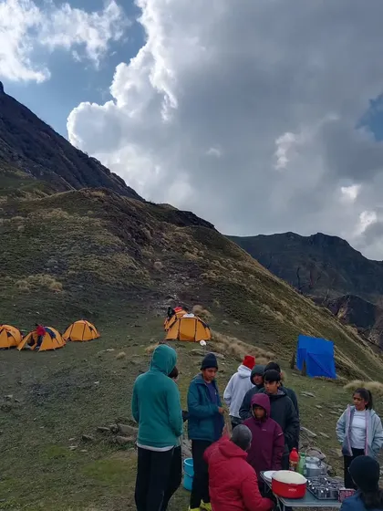 A group of our trekkers gathered at the campsite, getting ready for the day's activities. This shows the typical morning scene before we hit the trails, with the mountain slopes rising in the background.