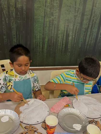 These two boys are concentrating on getting the base coat just right for their paintings. I guide the kids through each step, from preparing their surface to adding the final details.