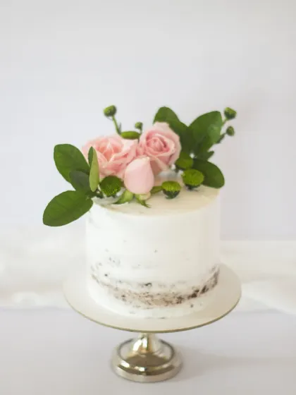 Simplicity wins with this semi-naked cake and fresh pink roses. The "less is more" frosting style allows a little of the cake to peek through, creating a lovely rustic texture.