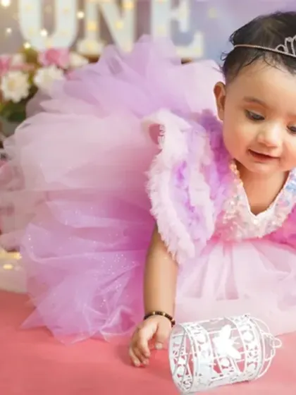 A little princess exploring her birthday setup. The tiara and fluffy dress make this first birthday shoot feel like a fairytale.