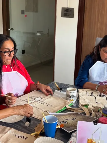 A group of friends enjoying a private tote bag painting party. It's a fun and relaxed way to catch up and get creative.