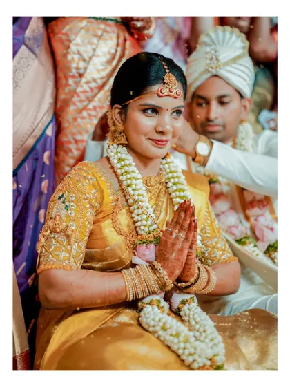 A serene portrait of a bride with her hands in prayer during her wedding ceremony, capturing a moment of devotion.