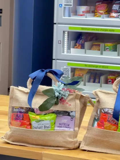 A branded jute bag hamper placed on a counter next to an office vending machine, perfect for a mid-day surprise for employees.