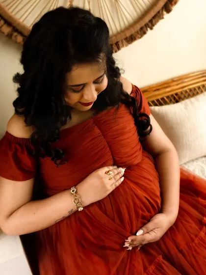 A quiet, downward glance at the baby bump. This close-up shot is full of emotion and anticipation, capturing the bond between mother and child.
