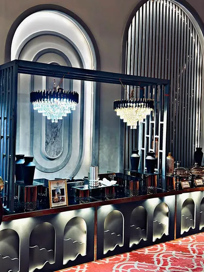 This art-deco inspired buffet station was designed for a sophisticated corporate gala. The custom framework, integrated chandeliers, and sleek black serveware create a dramatic and stylish focal point for the dining area.