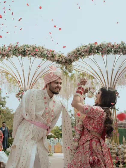 Another angle of the joyful Varmala exchange, with petals flying through the air.