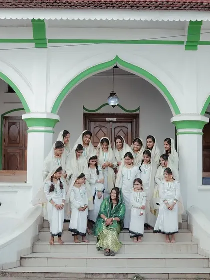 A group portrait of the bride and her female relatives, all dressed in coordinated outfits for the traditional Arikuth ceremony.