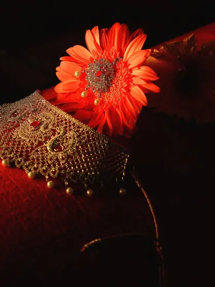 An artistic still-life photo of a bridal choker necklace, elegantly displayed with flowers.