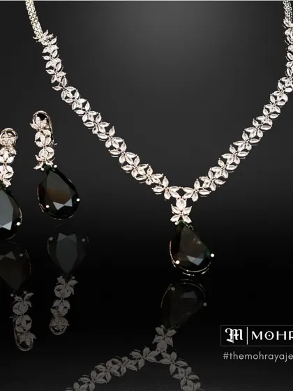 A delicate diamond necklace with black teardrop stones, offering a sleek and modern aesthetic for any special occasion.
