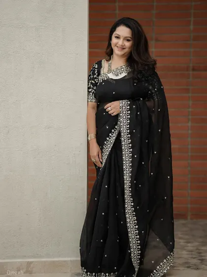 A full-length shot of the client in her black saree, the statement necklace being the star of the look.