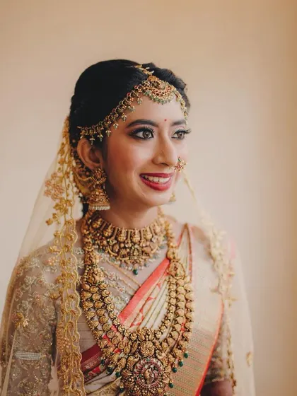 A beautiful bridal portrait. The sheer veil adds a layer of softness to her traditional look, which features a bold lip and perfectly defined eyes.
