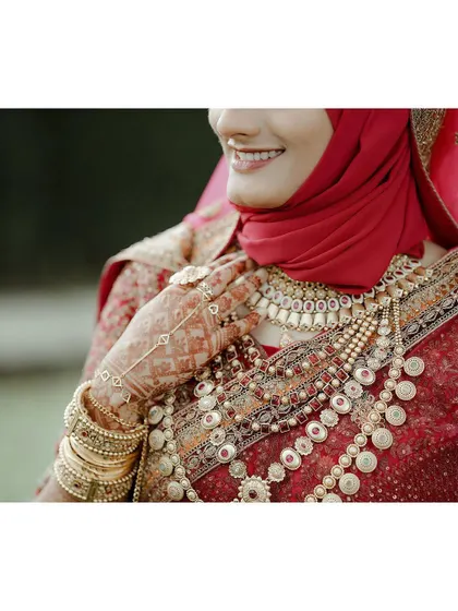A close-up on the bride's hands and magnificent jewelry, a testament to the rich details of a traditional Muslim wedding.