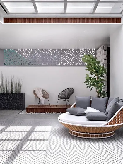 This view shows the connection between the indoor family lounge and the outdoor terrace, separated by slide-and-fold doors. The design uses a consistent color and material palette to create a seamless indoor-outdoor living experience.