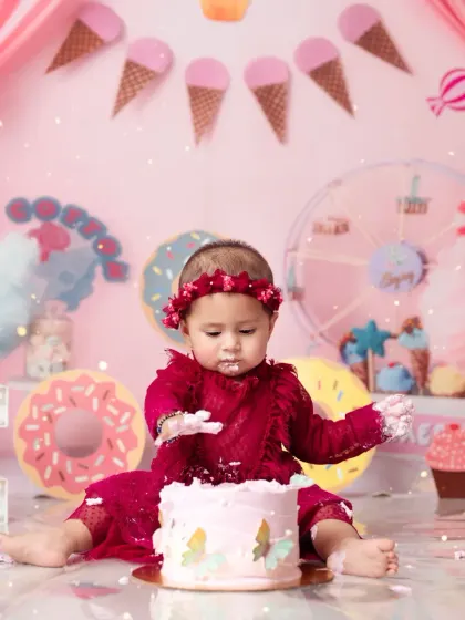 A sweet moment from a Candy Land cake smash, where this little girl is enjoying her first birthday treat.