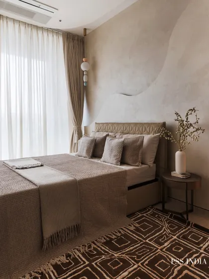 This bedroom showcases the art of layering textures for depth. A sculptural wave detail on the wall, an embossed leather headboard, and a mix of textiles on the bed create a rich, inviting, and tactile experience.