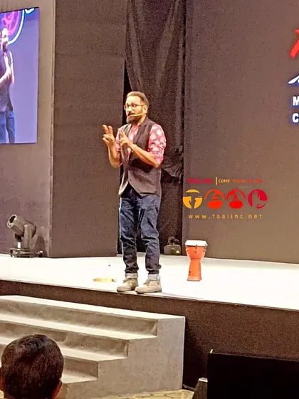 Another shot of Aman on stage, using hand gestures to guide the audience. Facilitation is about more than just drumming; it's about non-verbal communication, energy, and creating a safe space for participation.