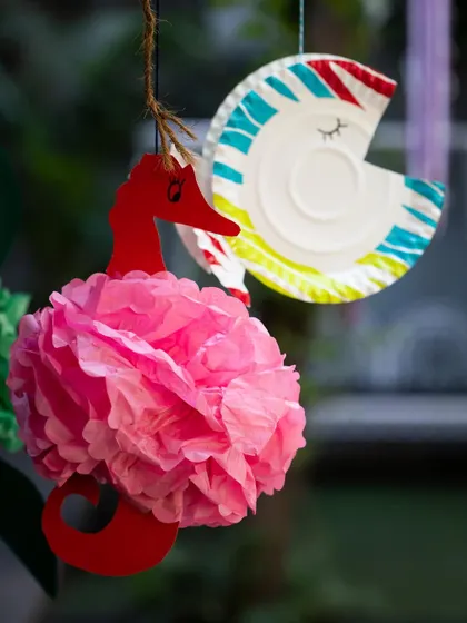 Details make the theme come alive. These handmade papercraft decorations, like a seahorse with a tissue paper body and a painted paper plate fish, add a charming and personal touch to the party decor.