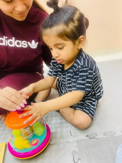 A duplicate of ID 91, showing a toddler's intense focus while playing with a toy, a sign of deep engagement and learning.