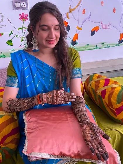 A serene shot of a bride admiring her intricate henna design, a moment of quiet appreciation for the art.
