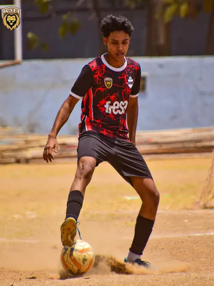 A player showing composure on the ball on a challenging dirt pitch. We train our players to adapt to all conditions.