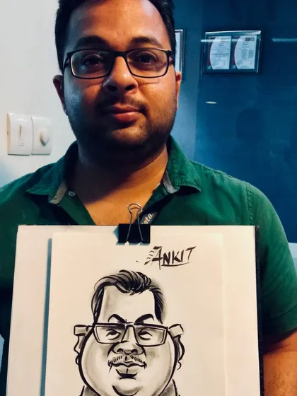 A guest holding his finished black and white caricature. The clip-on board allows me to work efficiently in any event setting.