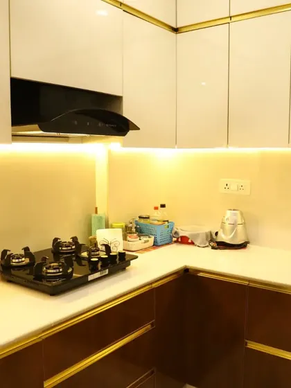 A close-up of the finished kitchen, showing the contrast between the dark wood lower cabinets and the bright, illuminated countertop and upper cabinets.