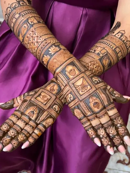 A unique bridal design with square-shaped blocks on the palms, each containing a different traditional symbol like a kalash (pot) or diya (lamp).
