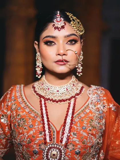 A regal portrait of the Nikkah bride. The makeup is designed to enhance her features and complement the heavy, traditional jewelry without being overpowering.