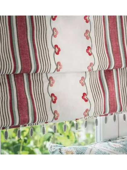 This woven striped fabric, featuring decorative floral embroidery, is a beautiful option for Roman blinds. The added tassels provide a final, bespoke detail that elevates the entire window treatment.