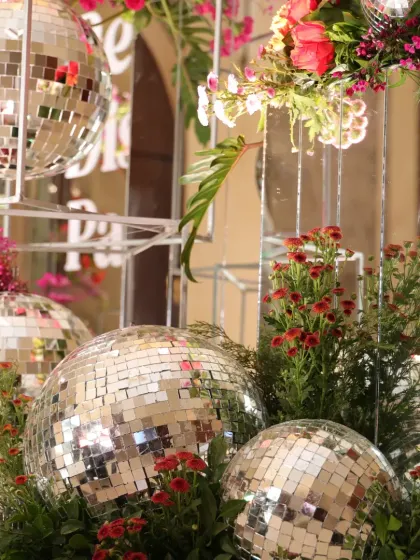 A close-up of the disco ball and floral arrangements, showing how reflective surfaces and bright colors were combined for maximum impact.
