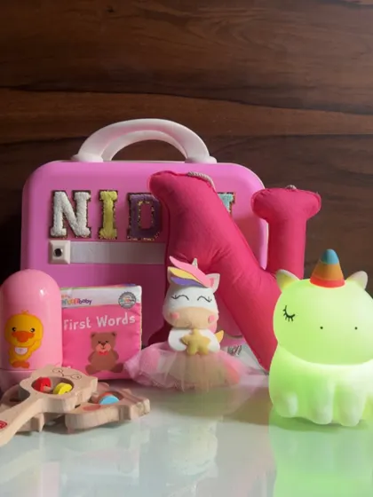 I absolutely love creating gifts for little ones. This personalized hamper for a one-year-old is filled with age-appropriate toys, a custom name suitcase, a soft unicorn plushie, and a gentle night light to make their day magical.