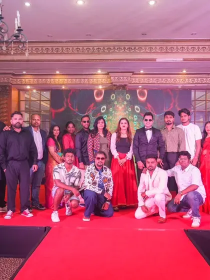 A group photo of a team on stage after a performance or presentation at a corporate annual day.