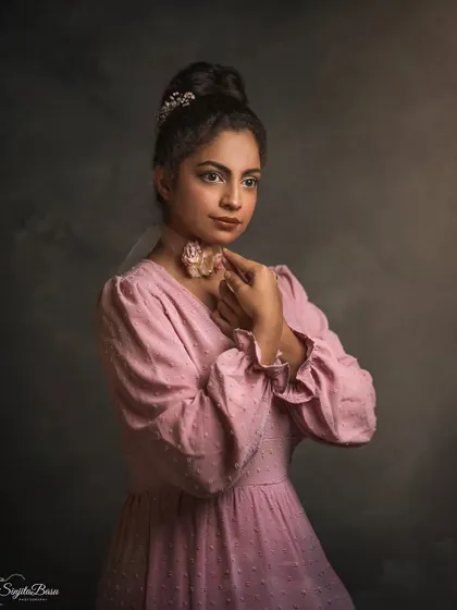Inspired by vintage aesthetics, this portrait features Divya with an elegant updo and a delicate floral choker. The lighting and painterly backdrop evoke the feeling of a 19th-century portrait, celebrating her milestone birthday with timeless style.