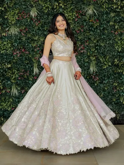 A full-length twirl shot. This showcases her beautiful pastel engagement lehenga and how the light and airy makeup look completes the entire ensemble.