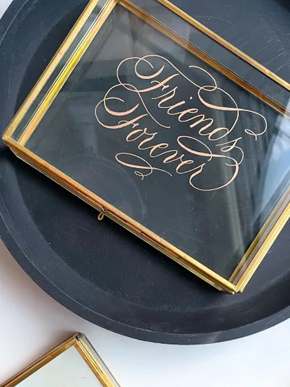 A single engraved glass box, styled simply to highlight the beauty of the calligraphy and the craftsmanship of the box itself.
