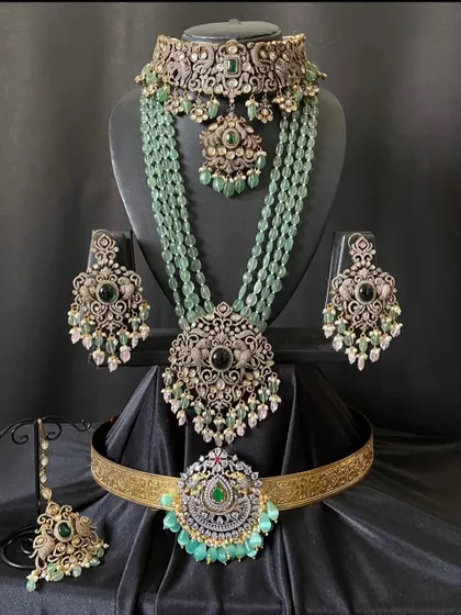 This elegant Victorian set features intricate metalwork with green stones and pearl drops. It's a sophisticated choice for a reception or engagement party.