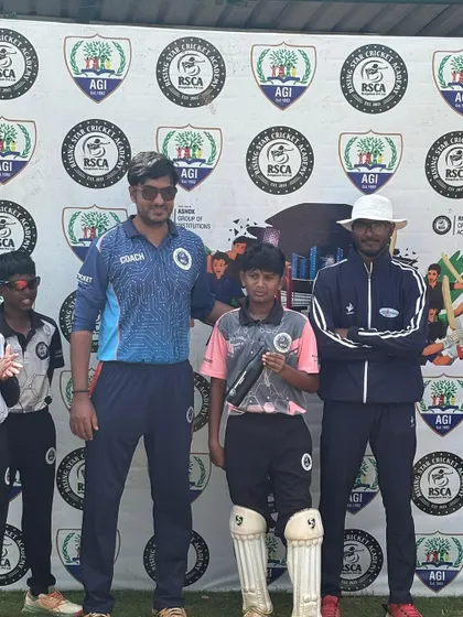 A player stands with his coaches after receiving an award, a proud moment for both the student and his mentors.