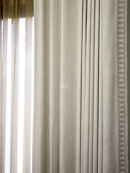 A close-up of our motorized curtains, showing the fine threadwork and embroidered border. This detail illustrates how we blend artistry with the convenience of smart home technology.