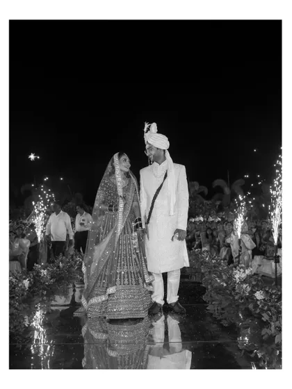 A dramatic black and white shot of the couple's entrance at their reception, with sparklers lighting up the aisle.