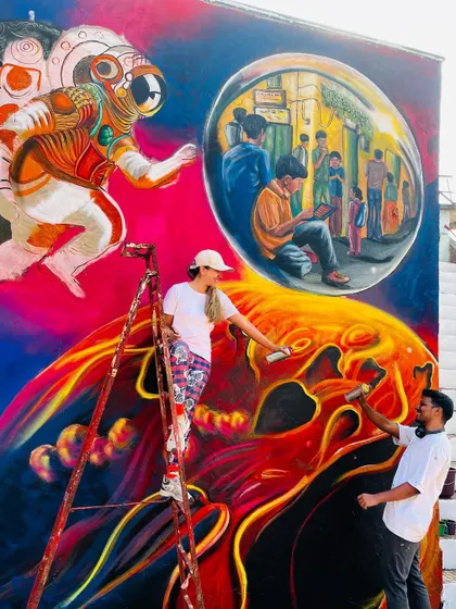 Working together on the lower sections of the mural. Every part of the wall, from top to bottom, was filled with detail and colour to create a fully immersive experience.