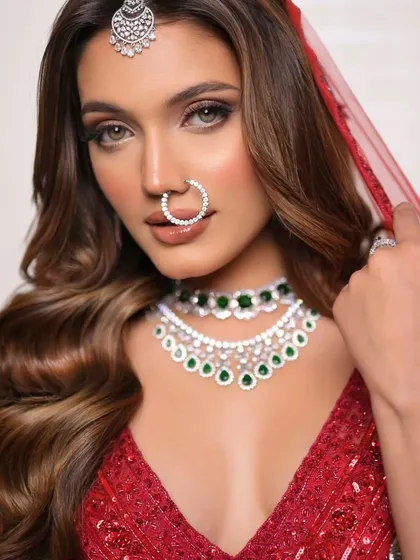 A modern take on the red bridal lehenga. This look features softer, bronze-toned smokey eyes and glowing skin for a subtle yet stunning effect.