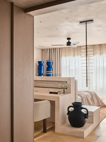 We designed this study nook as part of a larger bedroom suite, using a consistent palette of light wood and neutral tones. The bold blue ceramic vases add a surprising pop of color, showcasing our love for artful, unexpected details.
