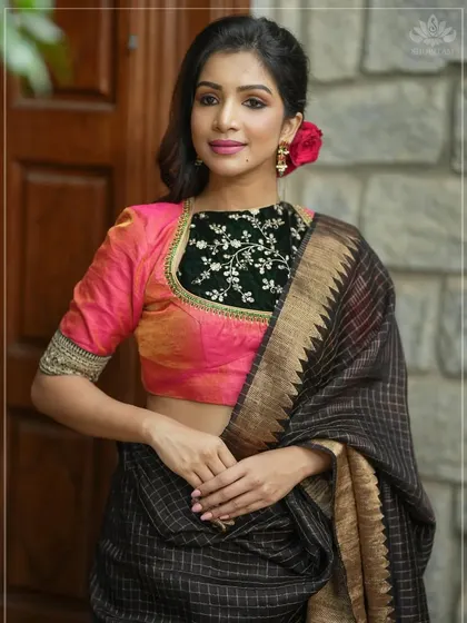 A unique blouse design combining a pink silk body with a black velvet yoke featuring delicate silver embroidery. The gold detailing on the sleeve cuffs adds an extra touch of luxury.