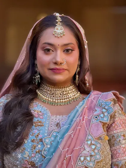 A regal portrait of the bride in her pastel lehenga and dupatta.