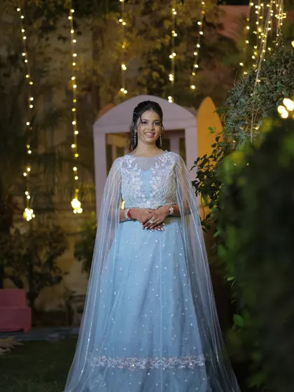 The perfect sangeet look under the fairy lights. The makeup is designed to catch the light beautifully, making her shine all night.