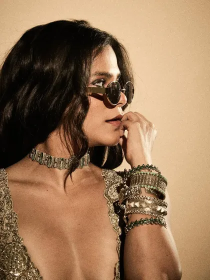 Adding a touch of cool to a traditional look. Pairing this embellished sharara with round sunglasses gives it an instant modern, edgy vibe, perfect for a daytime mehndi or an outdoor festival.