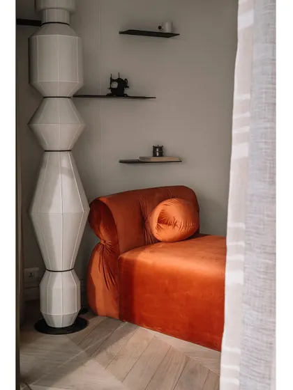 Another view of the master bedroom, showing the sculptural floor lamp and the minimalist shelving. Every piece is chosen to contribute to the room's overall sense of tranquility.